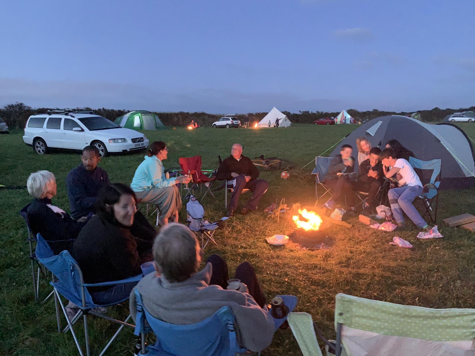Campers gathered around the campfire in the evening